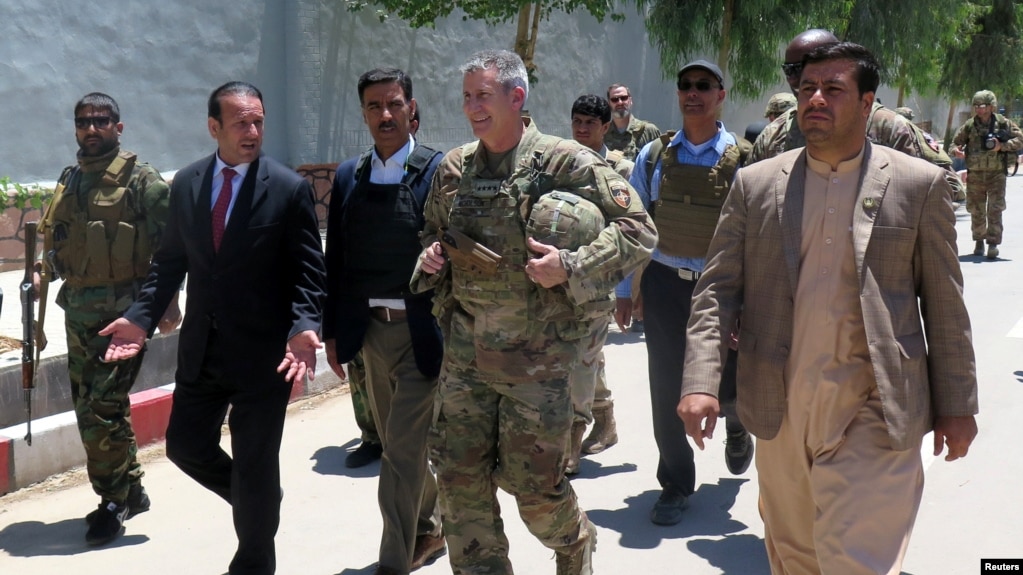 U.S. Army General John Nicholson, commander of Resolute Support forces and U.S. forces in Afghanistan, center, walks with Afghan officials during an official visit in Farah province, Afghanistan, May 19, 2018. Picture taken May 19, 2018. 