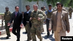 U.S. Army General John Nicholson, commander of Resolute Support forces and U.S. forces in Afghanistan, center, walks with Afghan officials during an official visit in Farah province, Afghanistan, May 19, 2018. Picture taken May 19, 2018. 