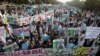 FILE - Students chant slogans while holding banners and posters showing Mumtaz Qadri, the alleged killer of Punjab governor Salman Taseer, during a rally to protest against any attempts to modify blasphemy laws, in Karachi, Pakistan, Jan. 20, 2011. Pakistani authorities on Feb. 29, 2016, hanged Qadri, a former police bodyguard. 