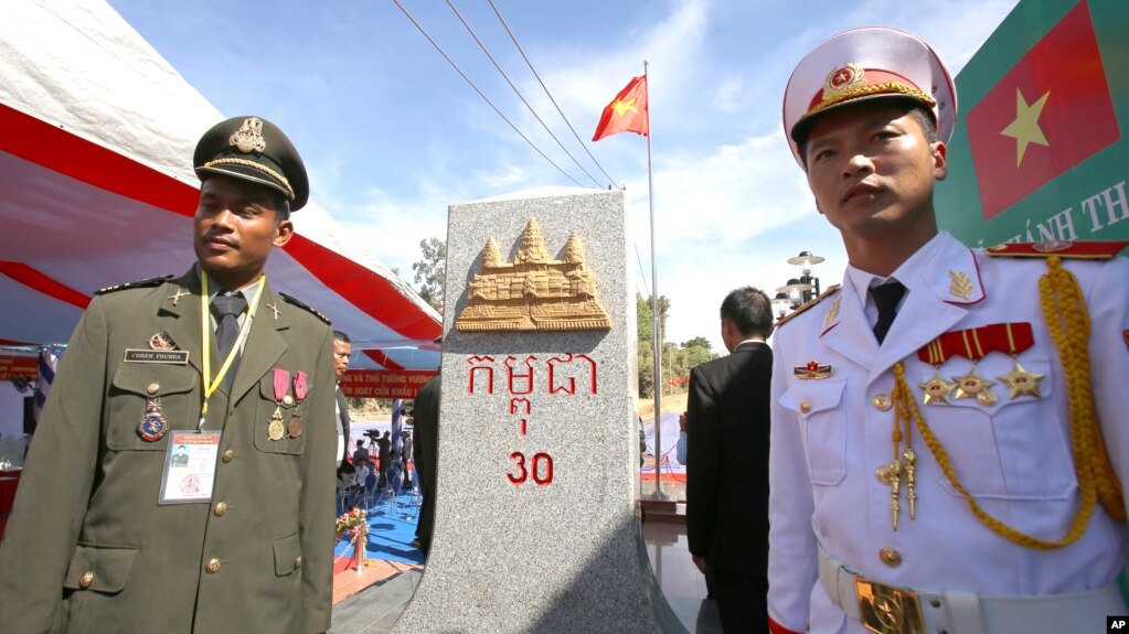 រូបឯកសារ៖ មន្ត្រីព្រំដែនរបស់កម្ពុជា(ឆ្វេង) និងមន្ត្រីព្រំដែនរបស់វៀតណាមឈរនៅខាងមុខបង្គោលព្រំដែនថ្មីមួយលើទឹកដីកម្ពុជា រវាងខេត្ត Gia Lai របស់វៀតណាម និងខេត្តរតនគីរីរបស់កម្ពុជា កាលពីថ្ងៃសៅរ៍ ទី២៦ ខែធ្នូ ឆ្នាំ២០១៥។