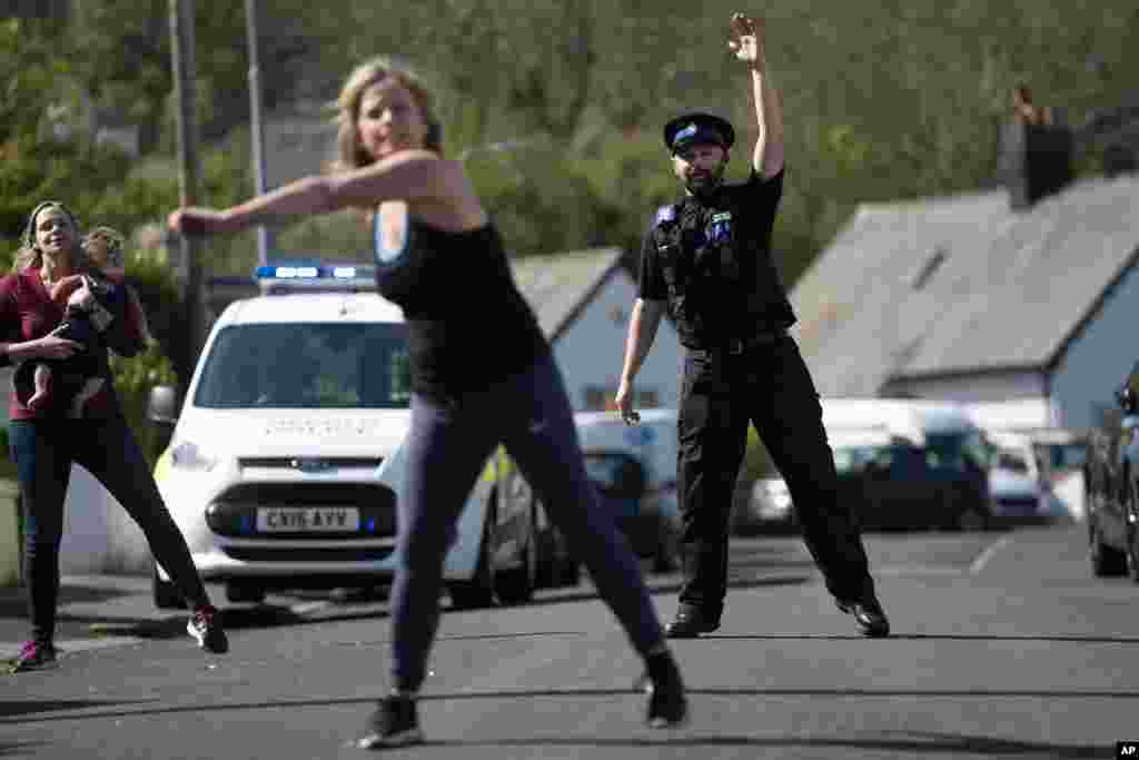 Police Community Support Officer Steve Gunning takes part in a dance session, organized by locals in north Wales, Britain, to help them keep fit, socialize and deal with the effects of COVID-19.