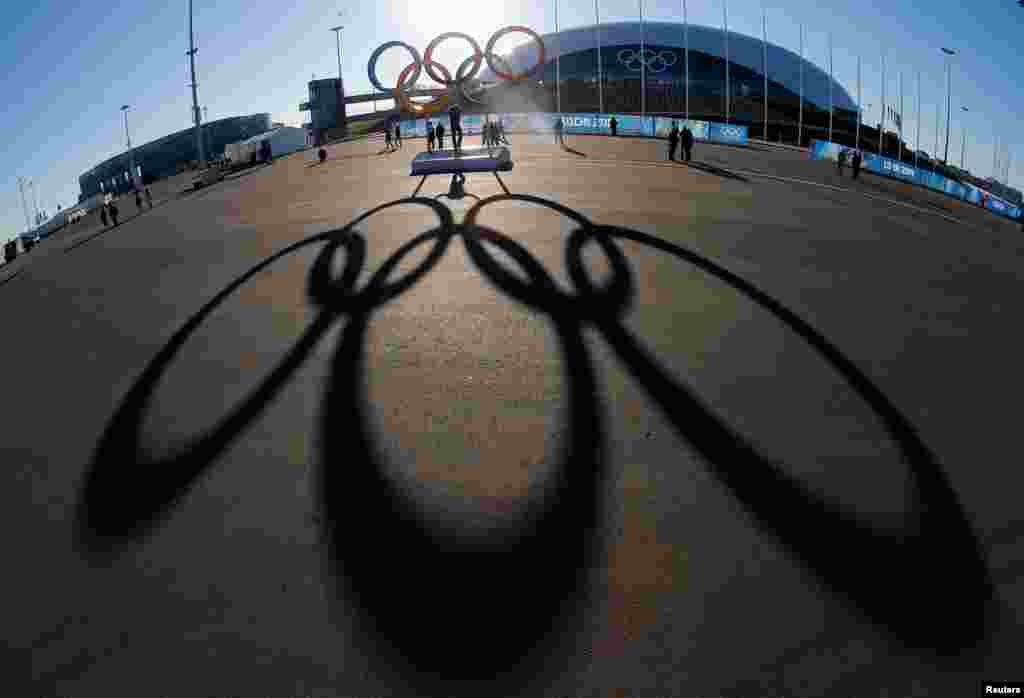 Những vòng tròn biểu tượng Olympic đổ bóng khi mặt trời lặn phía sau Nhà thi đấu trên băng Bolshoy trong khi công tác chuẩn bị vẫn tiếp tục tại công viên Olympic cho Thế vận hội mùa đông 2014 tại Sochi, Nga.