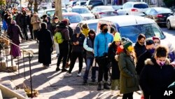 People wait in line to receive free COVID-19 rapid test kits, in Philadelphia, Pennsylvania, Dec. 20, 2021. Omicron has raced ahead of other variants and is now the dominant version of the coronavirus in the United States.