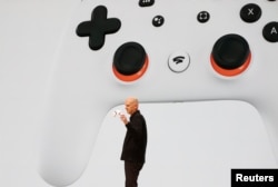 Google VP and GM Phil Harrison shows off the WiFi-enabled controller that lets players launch a microphone and use Google Assistant to ask questions. Another button lets users share gameplay directly to Google's video streaming service, YouTube.