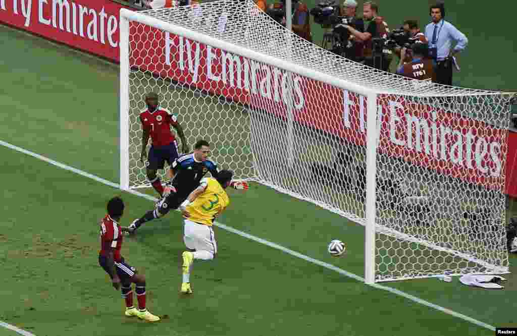 Brazil's Thiago Silva scores his team's first goal past Colombia's goalkeeper David Ospina at the Castelao arena in Fortaleza, July 4, 2014.