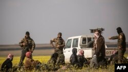 Men suspected of being Islamic State group fighters arrive at a screening point run by U.S.-backed Syrian Democratic Forces, where suspected jihadists, many of them wounded, were being interrogated outside Baghuz in northeastern Syria, March 6, 2019.