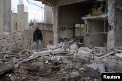 A man inspects a damaged house after an airstrike on al-Yadouda village, in Deraa Governorate, Syria, Feb. 15, 2017.