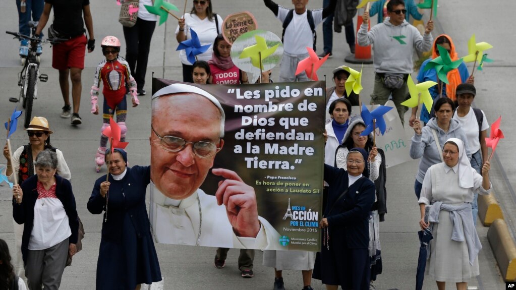 Para biarawati membawa poster Paus Fransiskus dan pesan dalam bahasa Spanyol: "Saya meminta Anda dalam nama Tuhan untuk Membela Bumi" dalam pawai untuk memerangi perubahan iklim Bogota, Colombia, 29 November 2015.