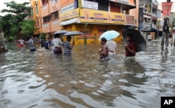 People wade through a flooded street in Chennai, in the southern Indian state of Tamil Nadu, Dec. 2, 2015.