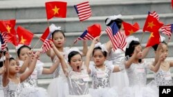 Vietnamese children wave flags before a welcome ceremony of U.S. President Donald Trump at the Presidential Palace in Hanoi, Vietnam, Sunday, Nov. 12, 2017.