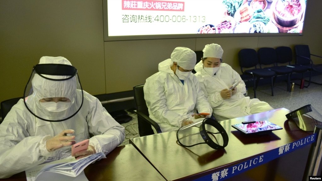 中国黑龙江省哈尔滨机场的公安人员身穿防护服进行旅客登记。(2020年4月11日)