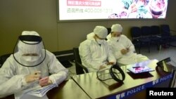 中国黑龙江省哈尔滨机场的公安人员身穿防护服进行旅客登记。（2020年4月11日）