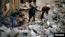 4일 이스라엘 군이 가자지구 북부 난민시설을 공습한 후, 팔레스타인인들이 무너진 건물 잔해를 수색하고 있다.
