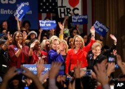 Democratic presidential candidate Hillary Clinton, center, is joined on stage by former Arizona Rep. Gabby Giffords, second from right, Leticia James, left, and New York City first lady Chirlane McCray, second from left, and others during a Women for Hill