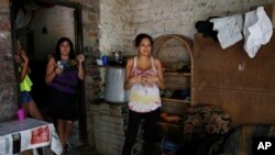 Kerly Ariza (right) is 17 years old and 20-weeks-pregnant. She stands at her home in Ibague, Colombia, Jan. 26, 2016. Ariza was diagnosed with clinical symptoms of the Zika virus and is awaiting for the results of laboratory tests. (AP Photo/Fernando Vergara)