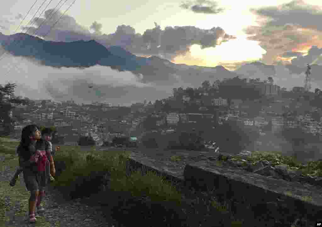 A Naga girl carries a child and walks up a hill as the sun sets in Kohima, capital of the northeastern Indian state of Nagaland.