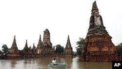 A man rows his boat past the Wat Chai Watthanaram temple which was hit by flood in Ayuttaha province, central Thailand, October 4, 2011.