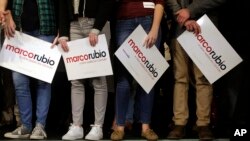 Supporters of Republican presidential candidate Senator Marco Rubio stand on a stage, holding placards before a campaign event in Exeter, New Hampshire, Feb. 2, 2016.