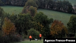 FILE - Hunters walk with a dog in Montamel, southwestern France, Nov. 7, 2021. Some people are accusing EU officials of introducing bears to the wild without considering the impact on local communities.