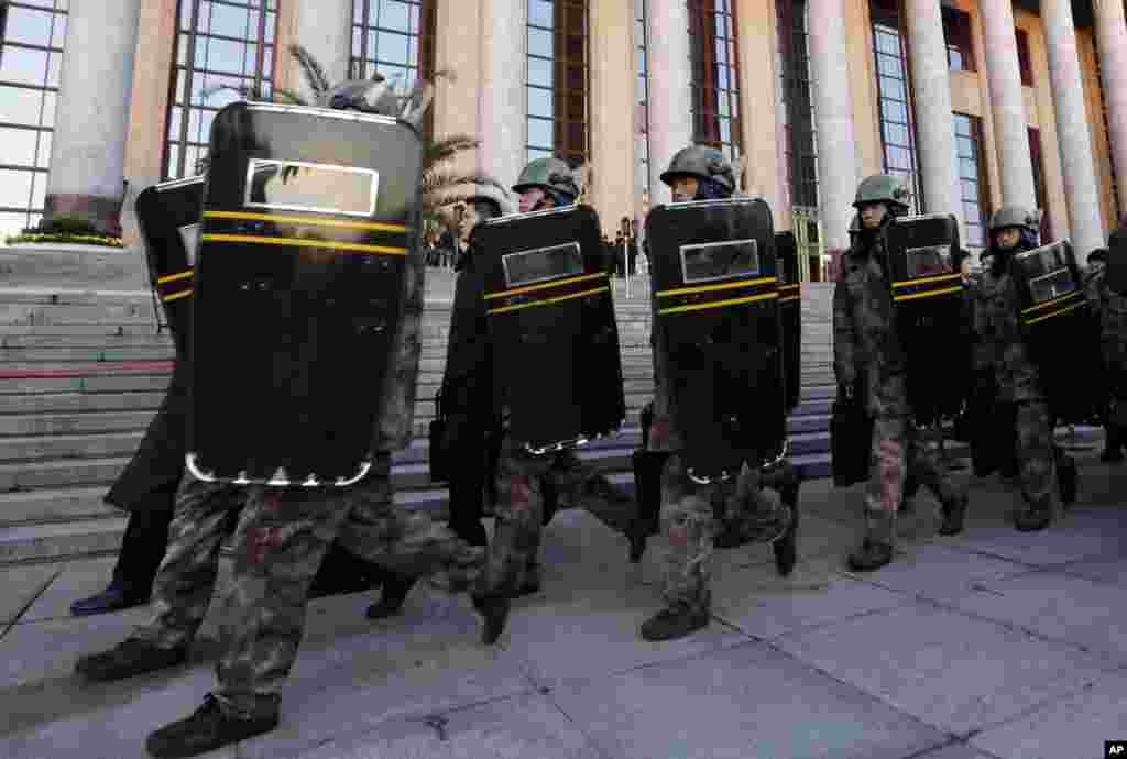 Chinese soldiers walk past the Great Hall of the People where the opening session of the 18th Communist Party Congress is being held in Beijing, November 8, 2012. 