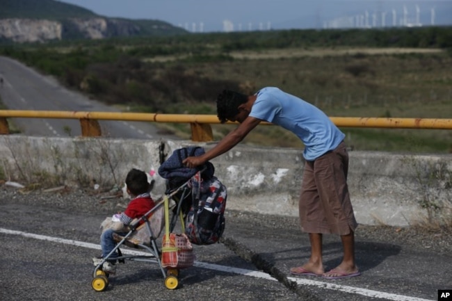 Un migrante empuja un carro de bebé por una carretera mientras una caravana de miles de migrantes centroamericanos sigue su lento avance hacia la frontera con Estados Unidos, entre Niltepec y Juchitan, en el estado de Oaxaca, México, el 30 de octubre de 2018.