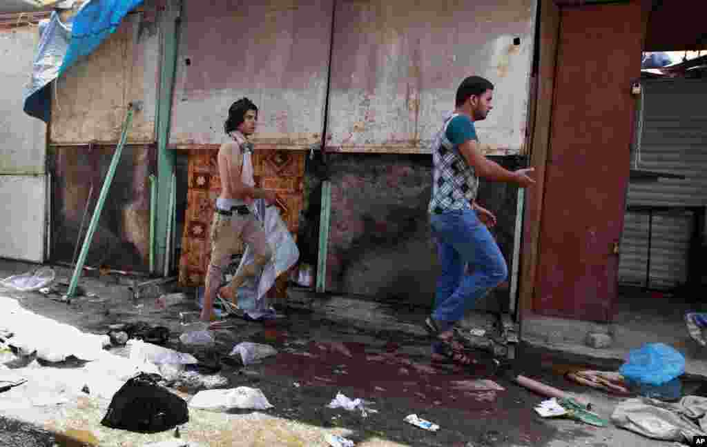 Civilians inspect the site of a bomb attack in Shorja Market in Baghdad, Iraq, July 17, 2014.