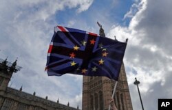 A pro-EU protestor waves flags opposite the House of Parliament in London, Apr. 4, 2019.