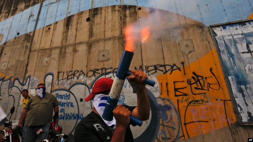 ARCHIVO - En esta foto de archivo del 26 de julio de 2018, un manifestante dispara un mortero casero mientras que otros se reÃºnen para conmemorar 100 dÃ­as de protestas antigubernamentales exigiendo la renuncia del presidente Daniel Ortega y la liberaciÃ³n de todos los presos polÃ­ticos en Managua, Nicaragua. El grupo de derechos, AsociaciÃ³n Pro Derechos Humanos de Nicaragua, que ha documentado asesinatos durante meses de disturbios polÃ­ticos, cerrÃ³ sus oficinas debido a amenazas y acoso y su lÃ­der huyÃ³ del paÃ­s. (AP Photo / Alfredo Zuniga).