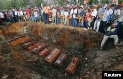 FILE - Coffins are seen arranged inside a mass grave during the burial of people killed when a dam burst its walls, overrunning nearby homes, in Solai town near Nakuru, Kenya, May 16, 2018.