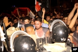 Iraqi riot police prevent protesters from storming the provincial council building during a demonstration in Basra, 340 miles (550 kilometers) southeast of Baghdad, Iraq, early Saturday, May 21, 2016.