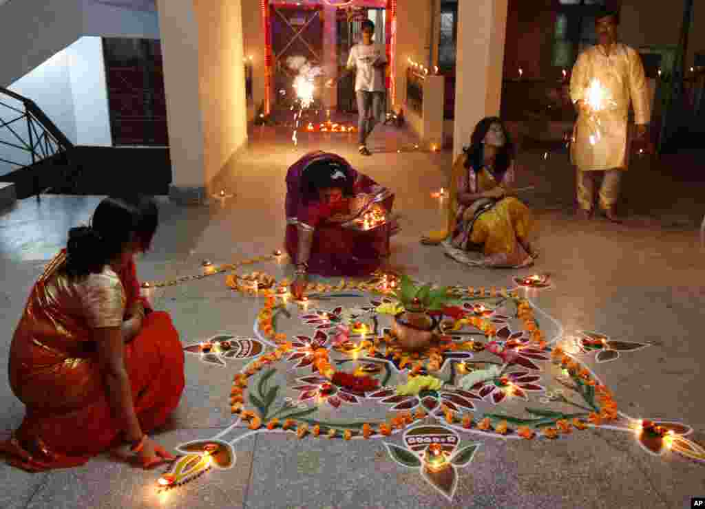 Indian Hindu women light earthen lamps to celebrate Diwali, Allahabad, India, Nov. 3, 2013. 