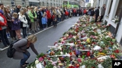 People gather to observe a minute's silence at noon in front of the Norwegian Embassy in Copenhagen. Anders Behring Breivik, the man who has confessed to Friday's twin attacks that killed 93 people in Norway, was arraigned in court Monday, July 25, 2011