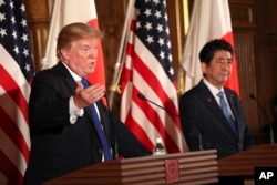 President Donald Trump, left, speaks as Japanese Prime Minister Shinzo Abe, right, looks on during a joint news conference at the Akasaka Palace in Tokyo, Nov. 6, 2017.