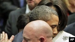 President Barack Obama embraces Mark Kelly (R), husband of critically wounded Congresswoman Gabrielle Giffords, at the end of a ceremony honoring the victims of a shooting rampage last Saturday on the University of Arizona campus, 12 Jan 2011