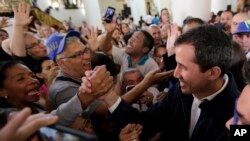 Opposition National Assembly leader Juan Guaido, right, who declared himself interim president, greets supporters as he leaves church after attending Mass in Caracas, Venezuela, Jan. 27, 2019. 