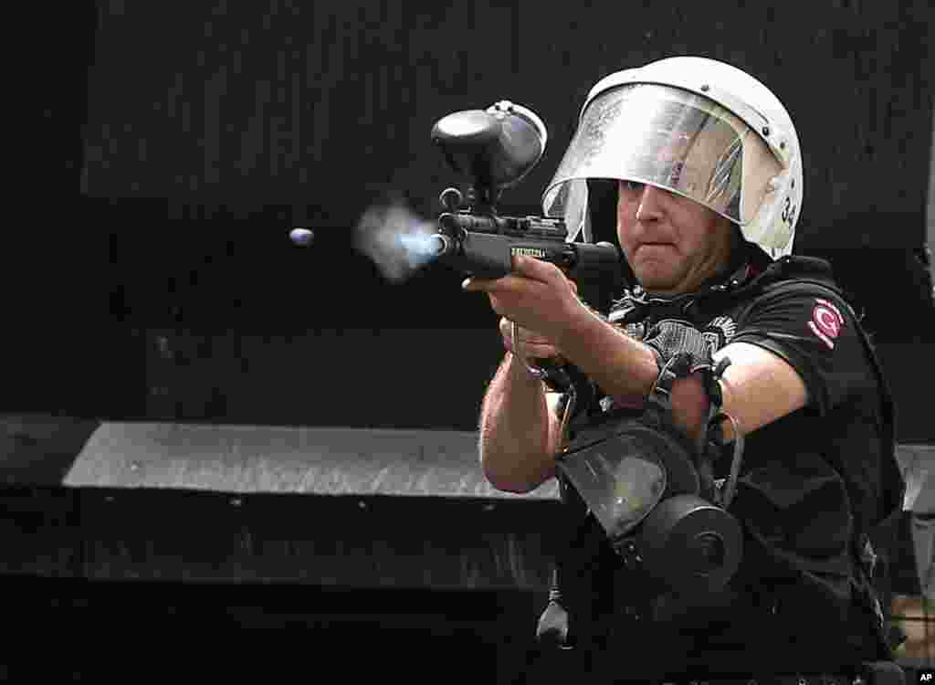 A police officer fires to disperse people who are protesting the Soma mine disaster that killed 301 miners, in Istanbul, Turkey. A protester was seriously injured during clashes.