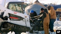 FILE - A photo from video provided by KXMB in Bismarck, N.D., shows cleanup beginning at a North Dakota encampment near Cannon Ball where Dakota Access oil pipeline opponents have protested for months.