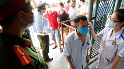 Người dân được kiểm tra thân nhiệt trước khi vào sân vận động xem bóng đá tại Nam Định hồi tháng 6/2020. Việt Nam vừa ghi nhận 2 ca tử vong vì COVID-19 sau 9 tháng không có người chết vì virus này. 
