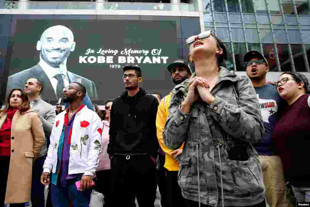 Mourners gather near an image of Kobe Bryant shown on a large screen outside the Staples Center after the retired Los Angeles Lakers basketball star was killed in a helicopter crash, in Los Angeles, California, Jan. 26, 2020.