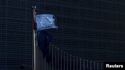 FILE - A European Union flag flutters outside EU Commission headquarters in Brussels, Belgium, Jan. 12, 2016.