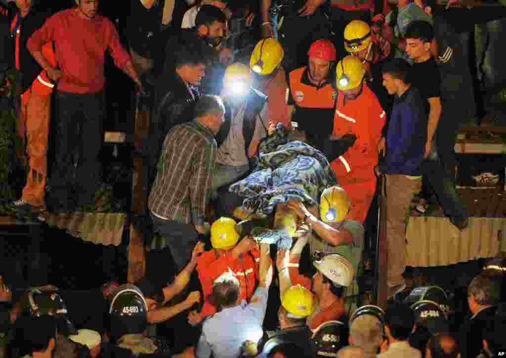 Miners carry a rescued friend hours after a deadly explosion and fire at a coal mine in Soma, western Turkey, May 13, 2014.