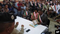 Madagascan member of parliament Malement Liahosoa, right, surrounded by fellow members, hands documents to the High Constitutional Court in Antananarivo, Madagascar, alleging the country’s president has repeatedly violated the constitution, May 27, 2015.