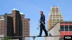 Nik Wallenda, on a wire three meters above a mostly empty parking lot, practices for his walk across Niagara Falls. (D. Robison/VOA)