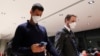 Serbian tennis player Novak Djokovic, left, walks in Melbourne Airport before boarding a flight, after the Federal Court upheld a government decision to cancel his visa to play in the Australian Open, in Melbourne, Jan. 16, 2022.