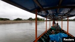 Boaters look at a beach where several uncontacted indigenous people have been spotted in recent years, near Diamante, a town in the Alto Madre de Dios River, Peru, May 26, 2014.