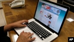 FILE - An Iranian checks the newly launched website of Iran's Intelligence Ministry, in Tehran, Iran