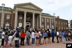 FILE - Hundreds of immigrants line up outside of Casa de Maryland to get help with documents and filling for the Deferred Action Childhood Arrivals applications in Langley Park, Maryland, Aug. 15, 2012.