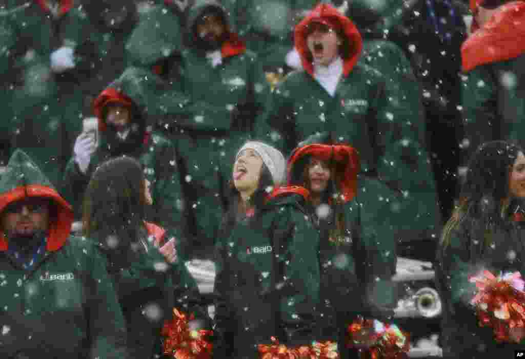 A Miami dance team member catches snowflakes during the third quarter of the Sun Bowl NCAA college football game between Miami and Washington State in El Paso, Texas, Dec. 26, 2015.