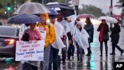 Los Angeles teachers walk on a picket line in pouring rain in front of Los Angeles High School during a city-wide teacher strike on Jan. 14, 2019. 