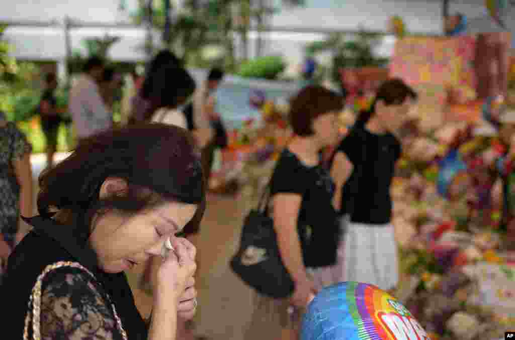 Sarah Kee, 61, wipes away her tears at an area set aside for tributes to former Singapore prime minister Lee Kuan Yew at the hospital where he passed away, Singapore, March 23, 2015.